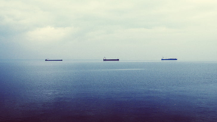 silhouette of ships on body of water