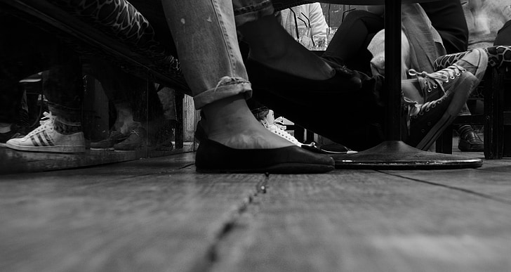grayscale photo of person foot wearing a slip on shoe