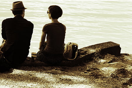 man and woman beside sea shore