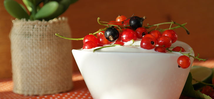 red and black currants on top on white cream