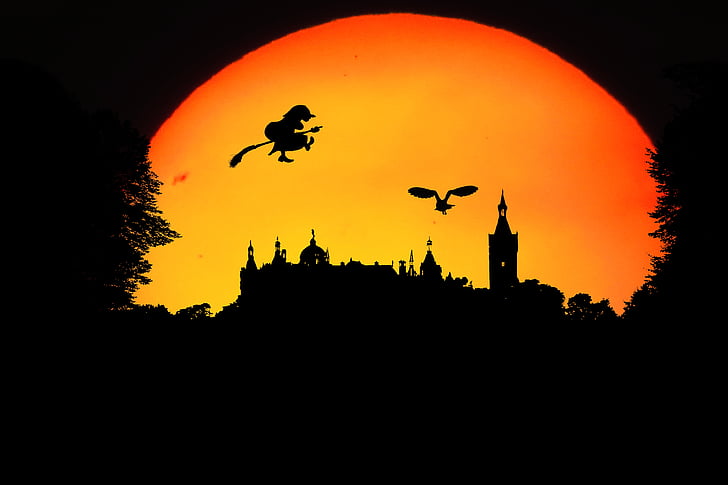 silhouette of witch and castle during sunset