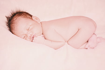 baby sleeping white surface