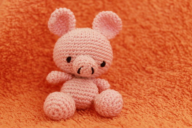 pink bear knitted plush toy on orange textile