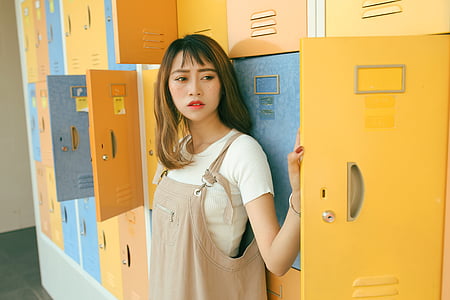 woman in white crew-neck T-shirt leaning on lockers