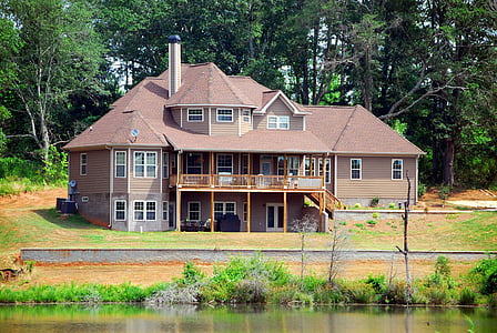 brown house near lake and trees