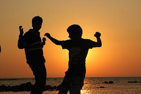 silhouette of persons dancing during sunset