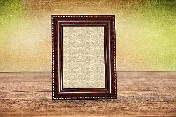 black photo frame on top of brown wood