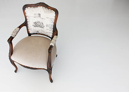photo of brown wooden framed white padded armchair