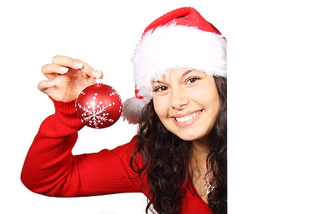 photo of woman wearing Christmas-themed tops and bubble hat holding ball