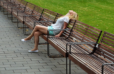 woman in white shirt sitting on park bench