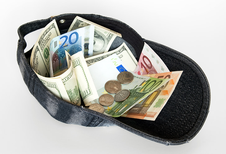 assorted banknotes and coins in black cap