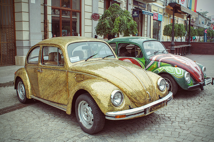 two assorted-color Volkswagen Beetle coupe