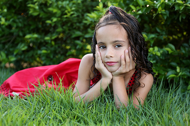 girl in red dress on green grass