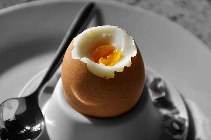 boiled egg on plate beside spoon