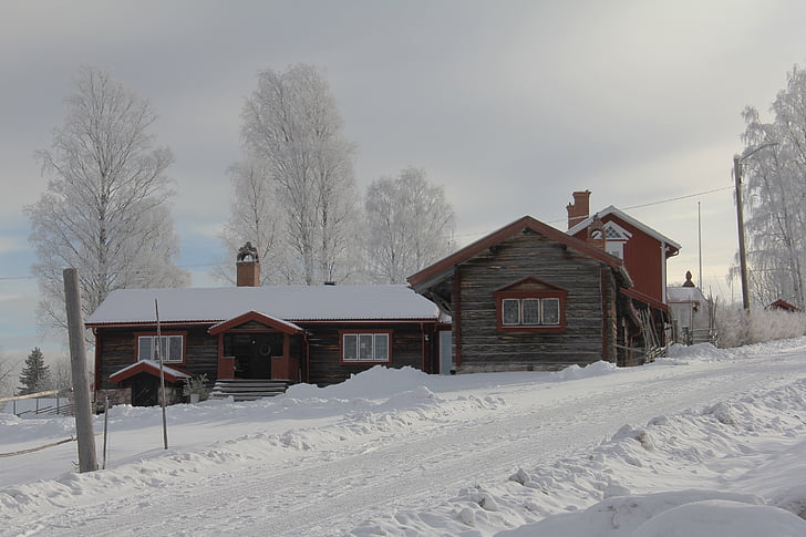 brown wooden house surrounded by snow