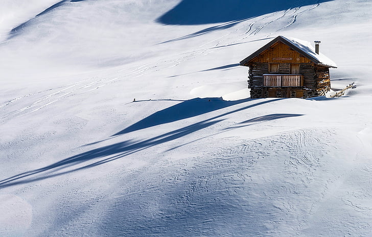 brown house on snow field at daytime