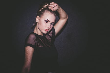 portrait photography of woman in black top with black background