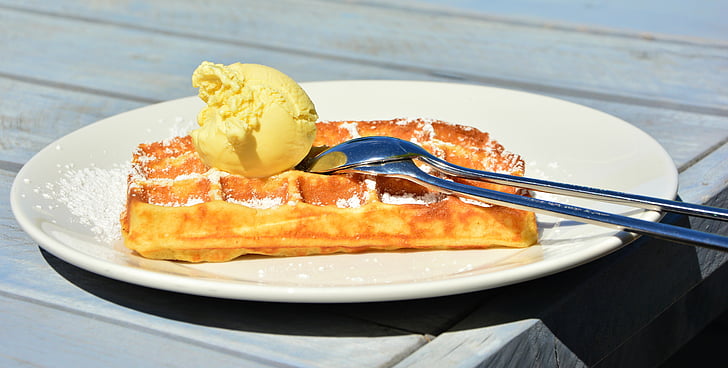 waffle with ice cream on top in white ceramic plate