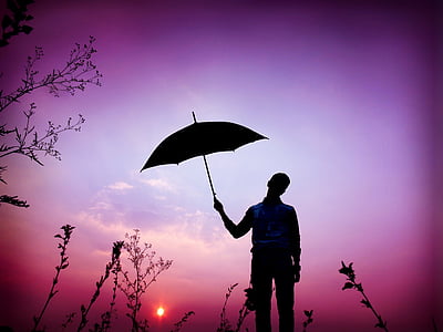 purple filter silhouette photography of man holding umbrella