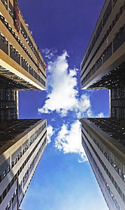 worm's eye view of two concrete buildings under blue sky