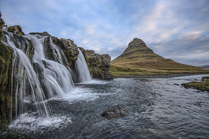 photography of waterfall with brown mountain on background