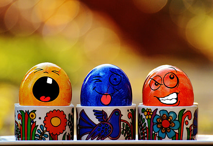 three assorted-color egg decors on cup selective focus photography