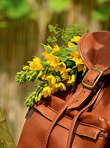 selective focus of leather backpack with flowers