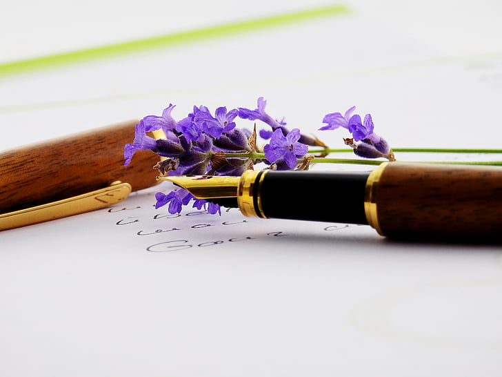 purple cluster flower beside brown fountain pen