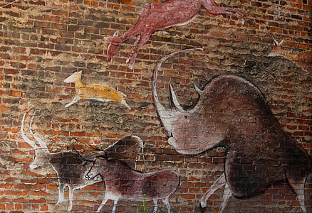several assorted animals engraved on brown brick wall