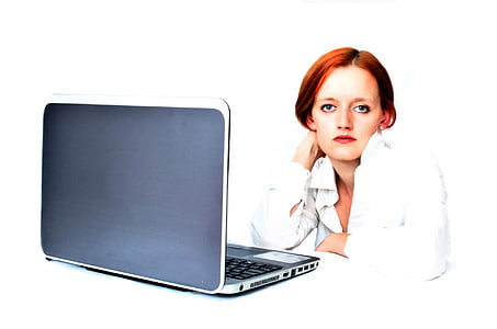 woman in white dress shirt sitting in front of black laptop