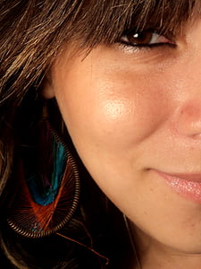 woman wearing brown and green dangle earring