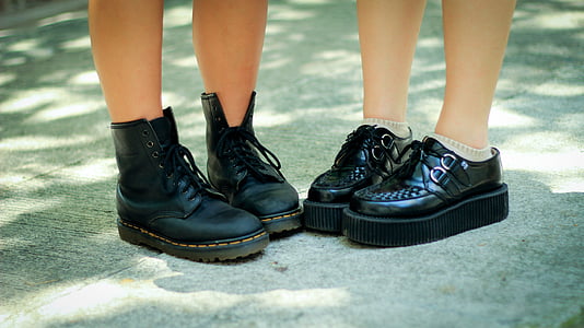 two person wearing black leather boots