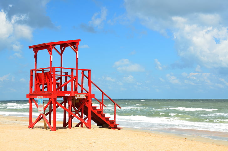red Lifeguard station beside sea