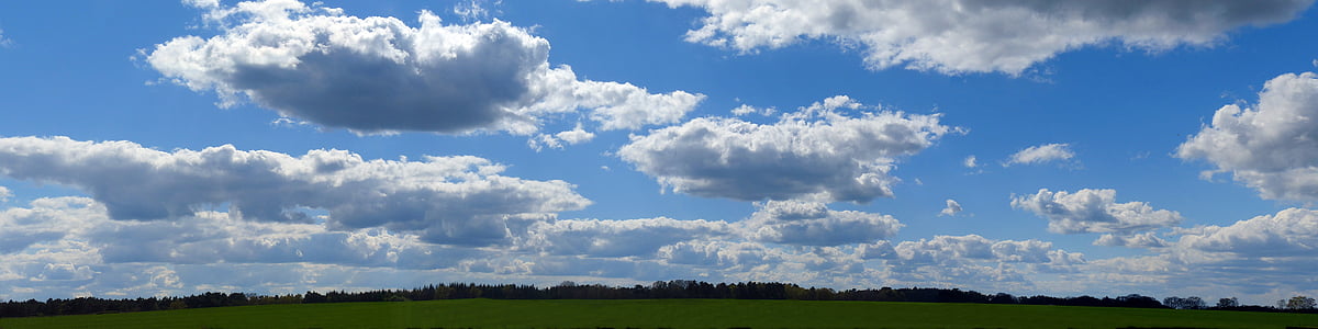 panorama photo of green loan under cloudy sky during daytime