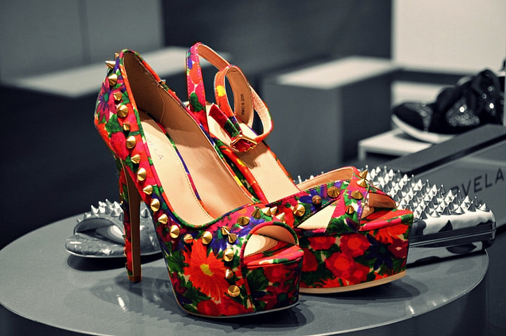 pair of red-green-and-black floral stiletto platform sandals on top of black table