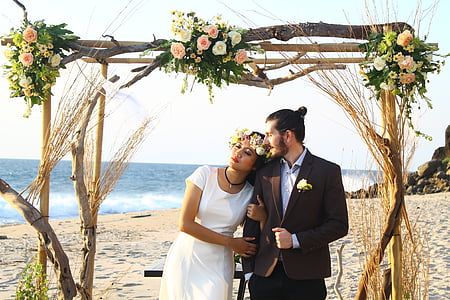 photo of bride and groom on seashore during daytime