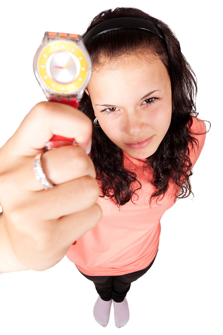 woman in pink top holding round silver-colored analog watch with red strap