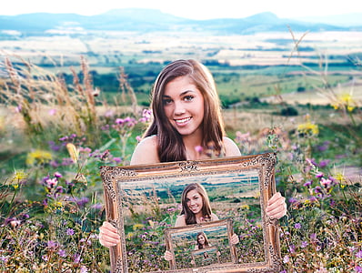 illusion photography of woman holding frame