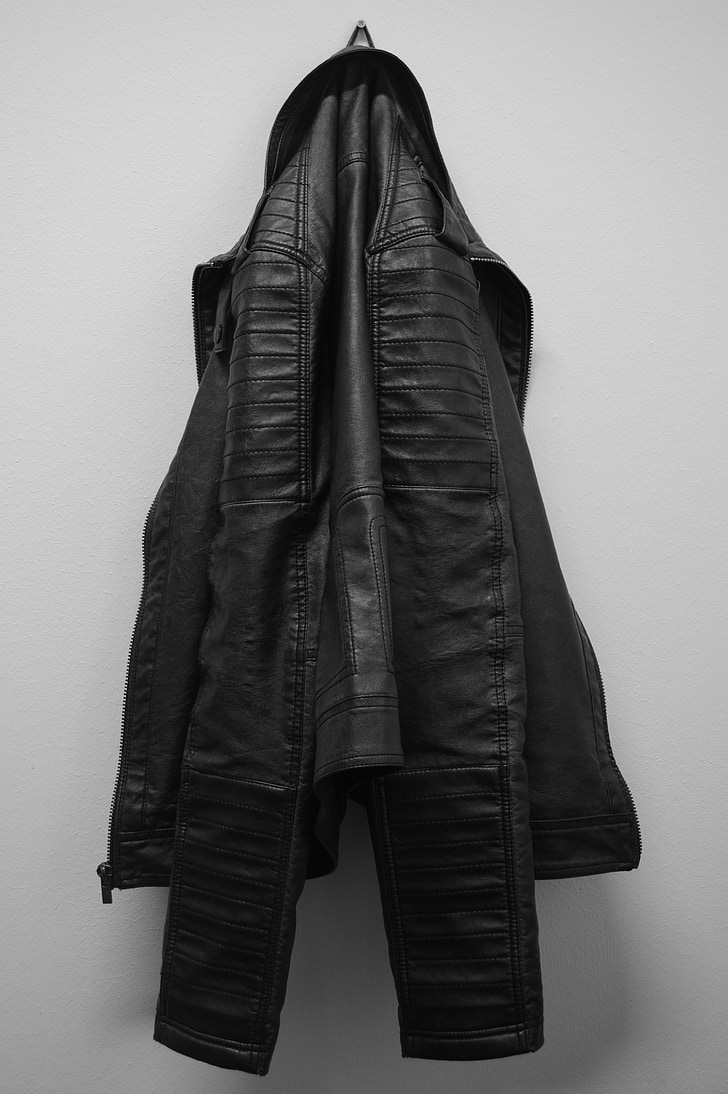 black leather jacket hanging on white wall