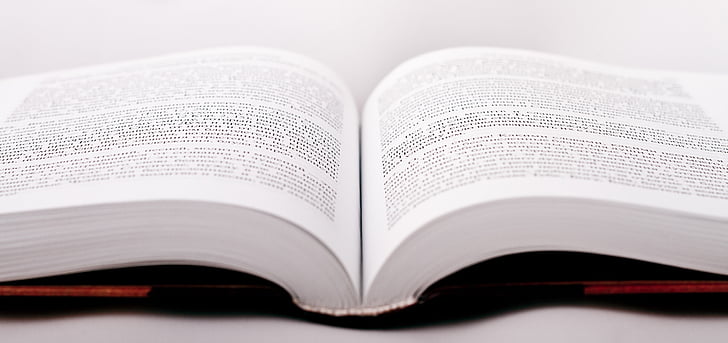 closeup photo of opened textbook on top of white surface