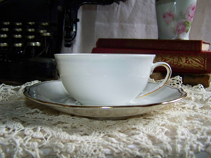 white ceramic teacup on white plate