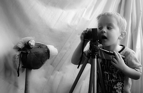 grayscale photo of boy using camera