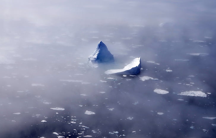 ice berg surrounded with fogs