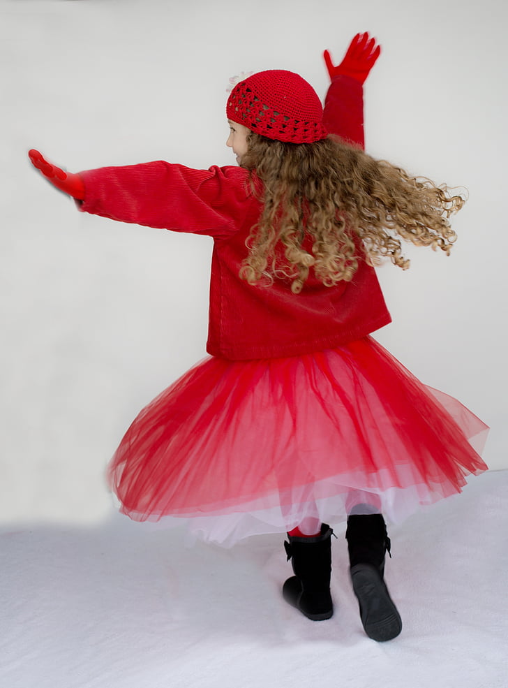 girl in red coat, tutu skirt, and hat