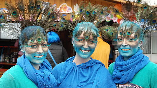 three woman wearing peacock feather headdress
