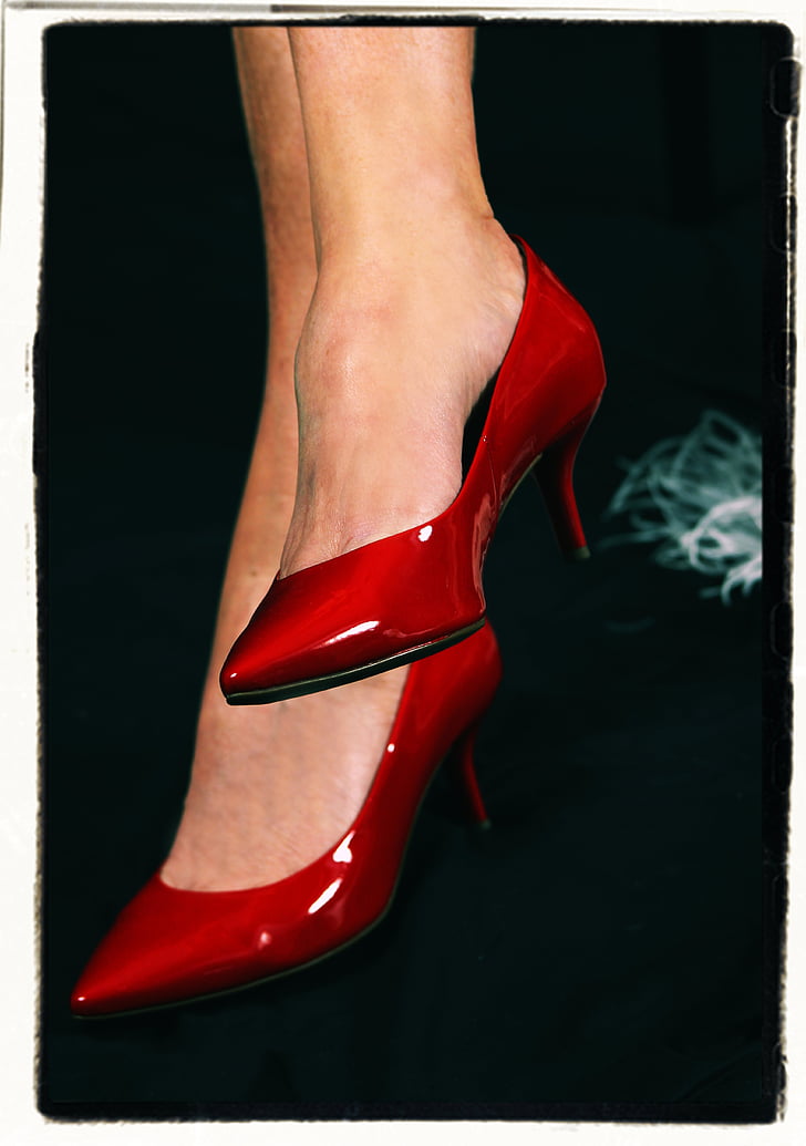 person wearing pair of red leather kitty heeled pointed-toe shoes