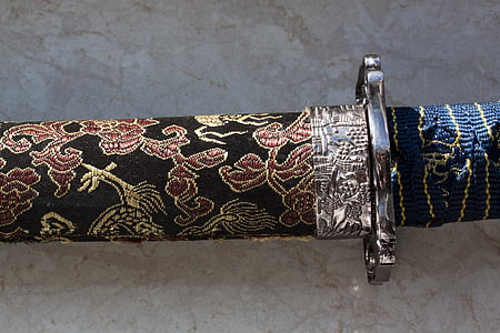 black handled sword with multicolored floral sheath