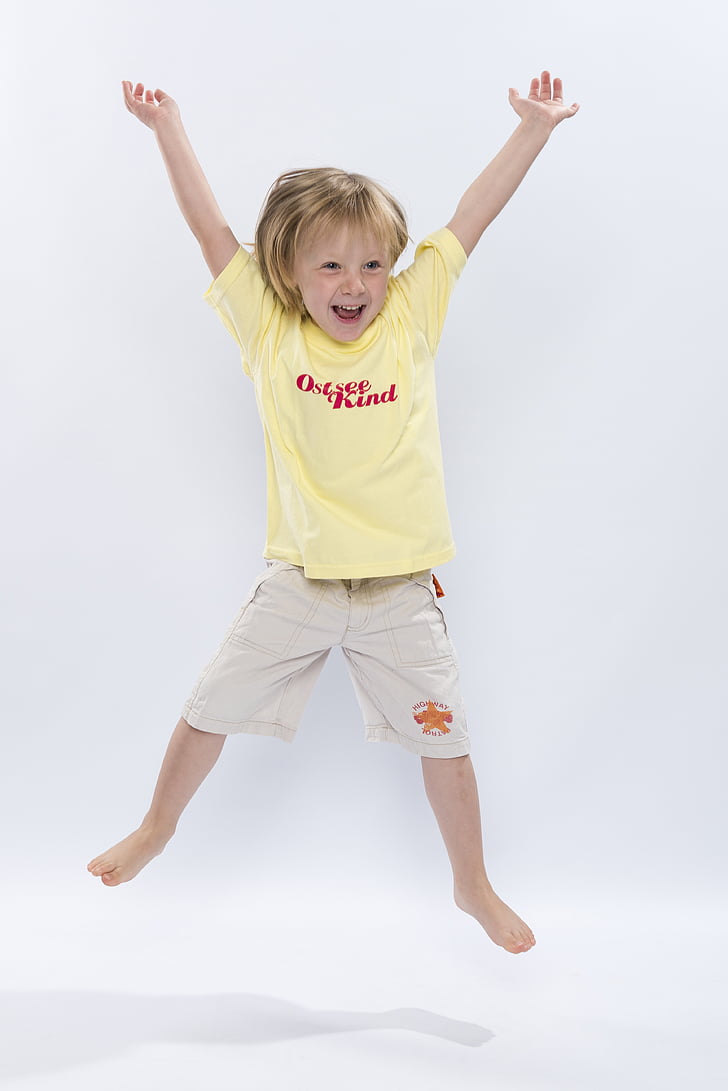 blonde haired child wearing yellow crew-neck shirt and beige shorts