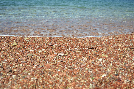 brown pebbles on seashore nearby sea