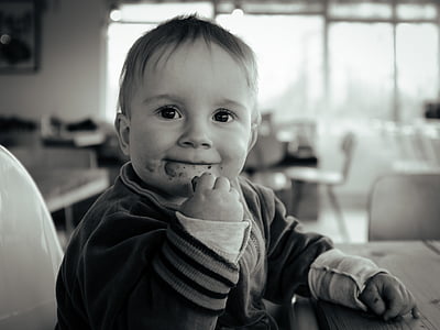 grayscale photo of baby eating